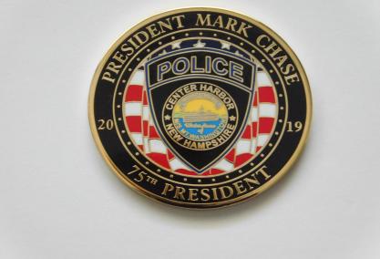 Close-up photo of 2 coins - one for NH Chiefs of Police and the other for President Andrew Shagoury